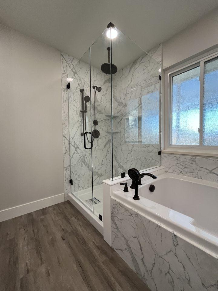 A large bathroom with a walk in shower next to a bathtub