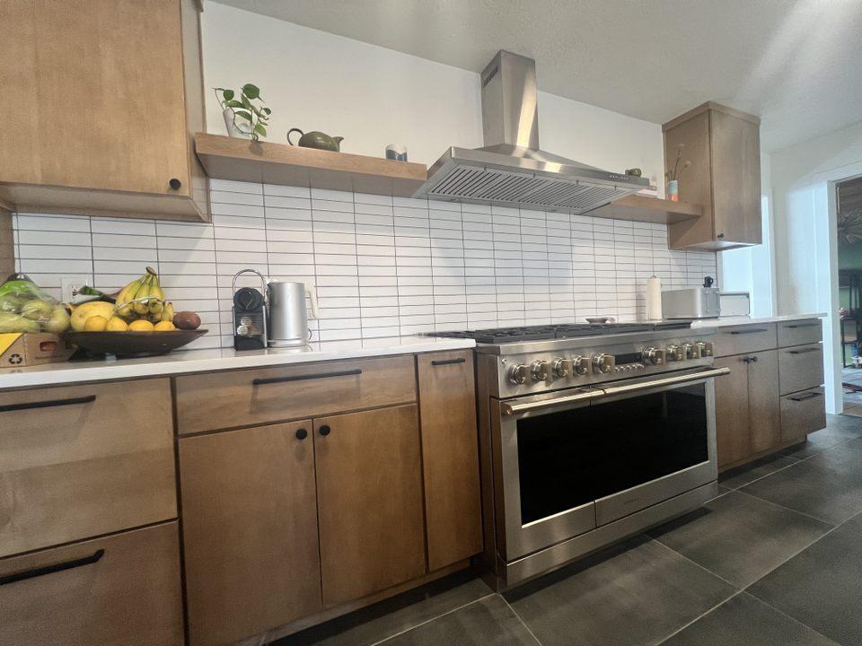 A kitchen with wooden cabinets and a stainless steel oven